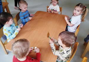 Dzieci siedzące przy stole podczas zajęć manualnych.