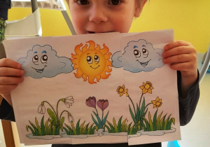 Chłopiec pokazuje swój wiosenny obrazek.
