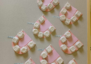 Zdjęcie tablicy grupy Motylki z wykonanymi przez dzieci buziami z ząbkami i języczkiem.
