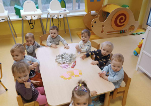 Zdjęcie dzieci z grupy Motylki siedzących przy stoliczkach i przygotowujących się do zajęć plastycznych z okazji Dnia Dentysty.