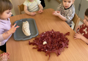 Dzieci przy stole lepiace jajka z masy solnej.