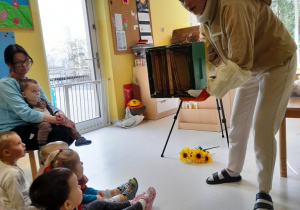 Pani Pszczelarka demonstruje dzieciom ul z ramkami odkładów pszczelarskich.