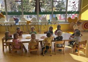 Zdjęcie dzieci z grupy Motylki siedzących przy stoliczkach, przygotowujących się do zajęć plastycznych z okazji Dnia Słońca.