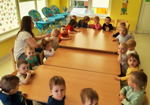 Dzieci z grupy Biedroneczki przy wspólnym stole przed rozpoczęciem zajęć.
