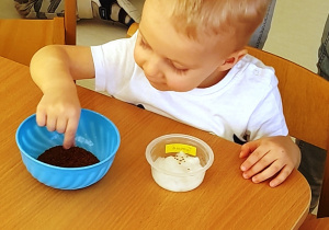 Chłopiec wybiera nasionka z miseczki.