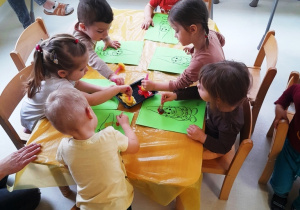 Dzieci przy wspólnym stole podczas pracy plastycznej.