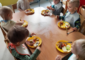 Dzieci przy stoliku konsumują świąteczne śniadanie.