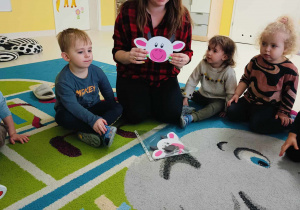Zdjęcie opiekunki pokazującej dzieciom szablon okrągłej krówki.