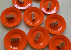 Zdjęcie talerzyków z rozłożonymi kawałkami upieczonego ciasta marchewkowego.