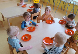 Zdjęcie dzieci kosztujących wykonane przez siebie ciasto marchewkowe.