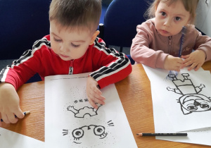 Dzieci malujące postać wydrukowanej Kici Koci.