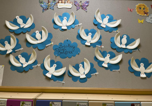 Zdjęcie tablicy grupy Motylki z wykonanymi przez dzieci papierowymi gołąbkami.