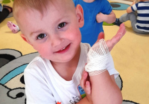 Chłopiec z bandażem na dłoni.