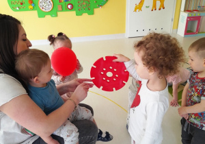 Dziewczynka pokazuje opiekunce okrągły, czerwony klocek.