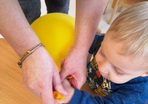 Opiekunka stawia chłopcu żółty stempelek.