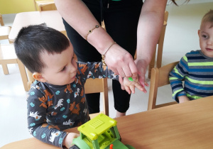 Opiekunka stawia chłopcu na dłoni zielony stempelek.