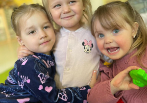 Zdjęcie trzech dziewczynek pozujących w uścisku.