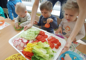 Albert, Emilka i Wiktoria mają przed sobą tacę pełną kolorowych warzyw.