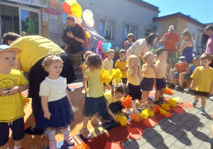 Zdjęcie dzieci z grupy Pszczółki przygotowujących się na dywanie do rozpoczęcia swojego pierwszego występu.