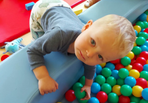 Jakub bawi się w basenie z kolorowymi piłeczkami.