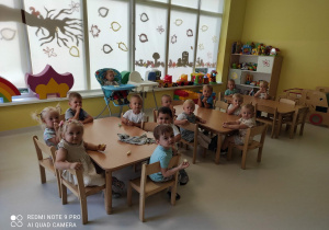 Zdjęcie dzieci z grupy Pszczółki siedzących przy stoliku podczas spożywania pierwszy raz 2-go śniadania po powrocie z wakacji.