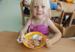 Uśmiechnięta Aleksandra pozuje do zdjęcia, podczas nabierania łyżeczką lodów.