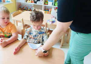 Opiekunka daje Stanisławowi brokatowe naklejki w kształcie gwiazdek.