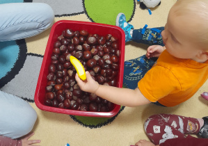 Chłopiec wyłowił z miski zabawkowego banana.