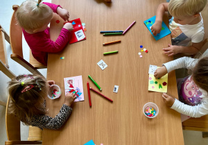 Zdjęcie dzieci dekorujących swoje listy kolorowymi aplikacjami.