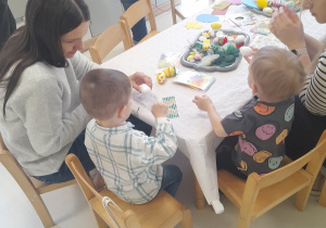Chłopiec z mamą tworzą swoje ozdoby wielkanocne.