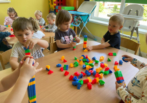 Dzieci w skupieniu bawią się klockami.