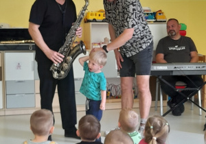 Chłopiec słucha dźwięku z instrumentu.