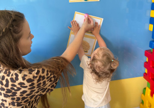 Dziewczynka wieszająca obrazek